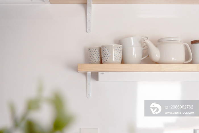 キッチン棚とマグカップとティーポット　白い壁　キッチン　イメージ写真　シンプル　ナチュラル　おしゃれ　白い食器　ホワイトスペース　文字スペース　コピースペース　余白
