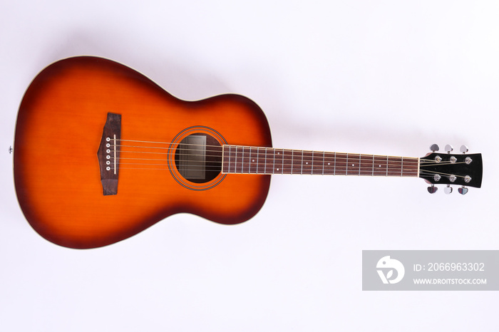 Folk style parlor acoustic guitar isolated on white background with a lot of copy space for text. Studio shot of travel size musical instrument. Close up.