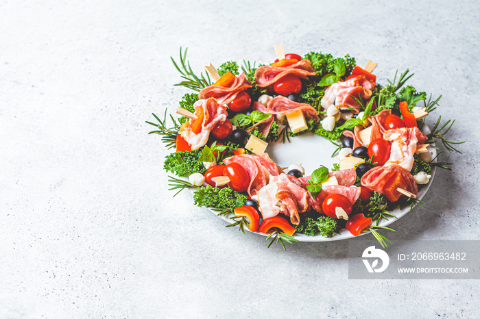 Christmas wreath of festive appetizer. Canapes with cheese, vegetables and ham, copy space. Christmas food concept.