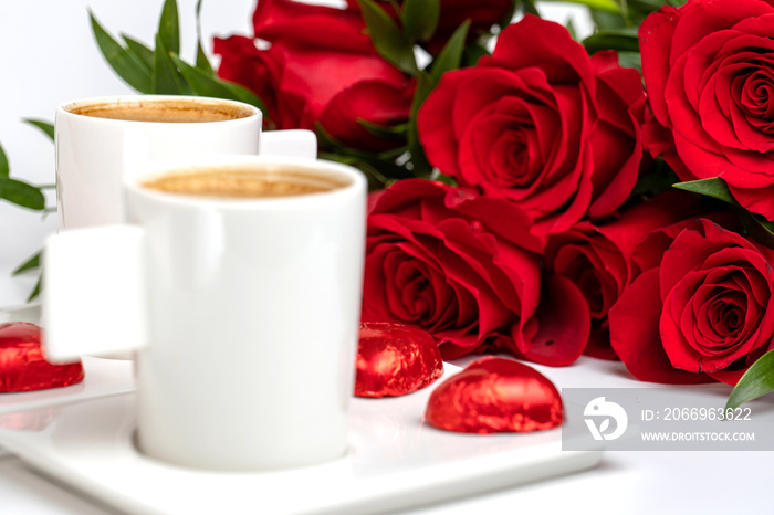 cup of coffee and a bouquet of red roses on a white table