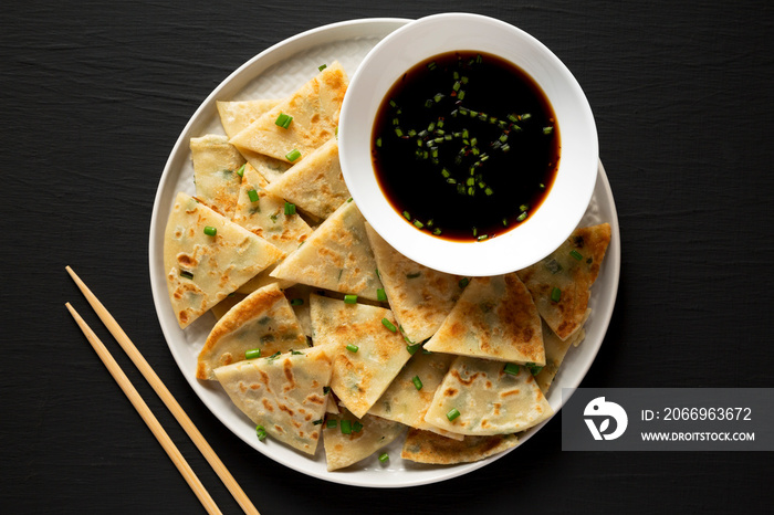 Homemade Scallion Pancakes with Soy Dipping Sauce on a black surface, top view. Flat lay, overhead, from above.