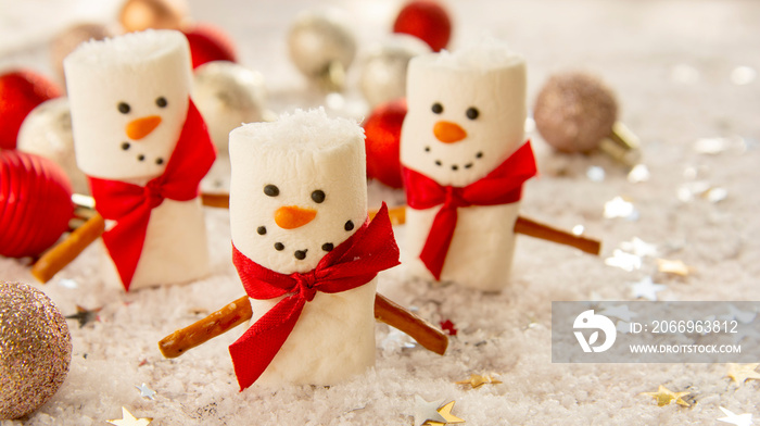 Marshmellow snowmen with snow and gliter, Christmas food background