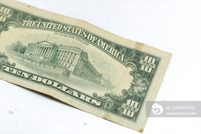 The reverse side of old 10 $ ten American dollars bill banknote series 1988 features  the U.S. Treasury Building, selective focus of vintage retro old American money note isolated on white background