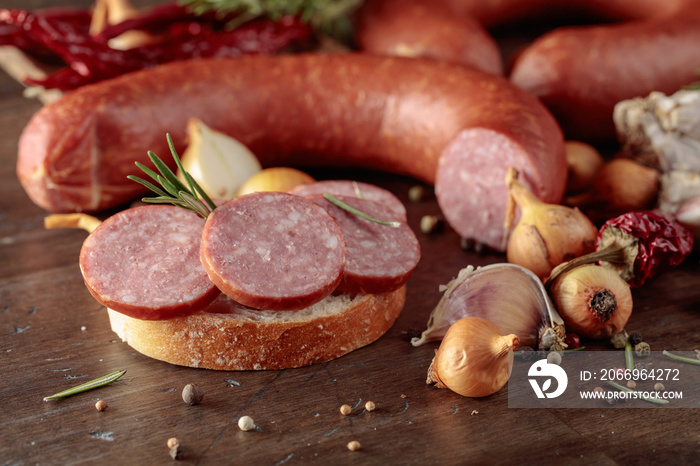 Sandwich with salami on a old wooden table.