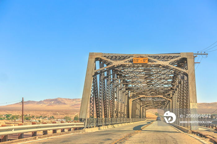 Iron bridge over the railroad in Barstow California on the historic Route 66 with Mojave desert on background. North 1st Street Bridge.