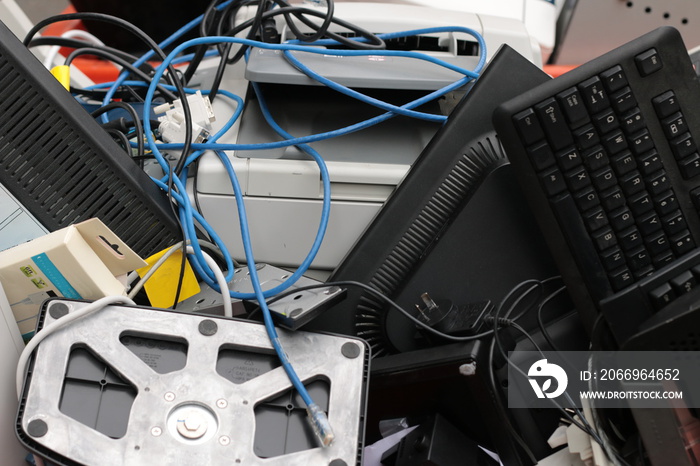 a pile of plastic technology waste and used broken office equipment heaped in a rubbish bin being taken for disposal