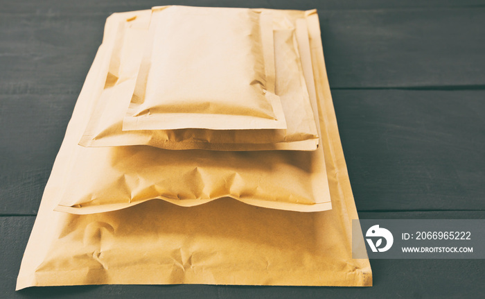 Four different size of paper envelopes on the wooden table