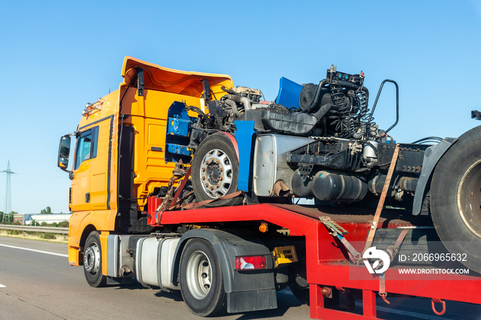 POV heavy industrial truck semi trailer flatbed platform transport wrecked salvage lorry chassis and cabin machine on common highway road at bright day sky. Scrap collision vehicles disposal service