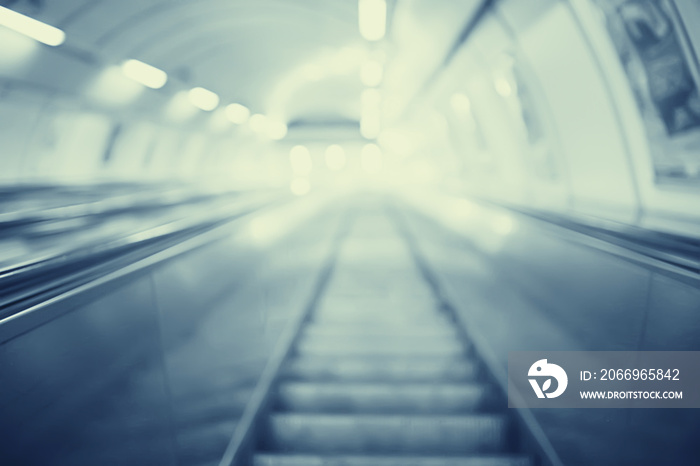 blurred background metro escalator / light blue background movement city infrastructure subway