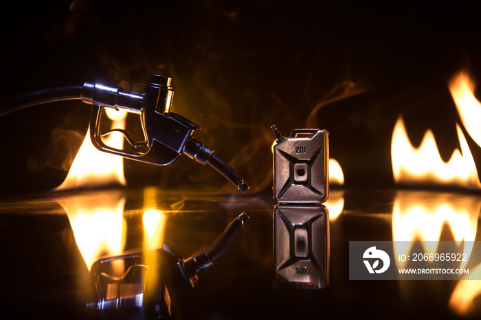 Creative concept. Silhouette of gasoline pistol miniature on dark toned foggy background. Close up. Industrial decorated elements on background.