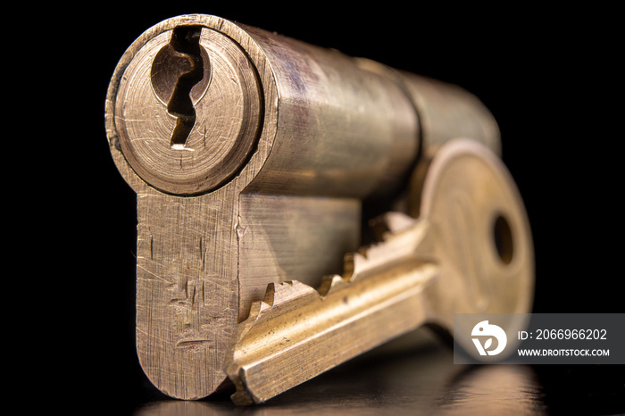 A old door lock on a dark background. A patent and keys to secure the front door.