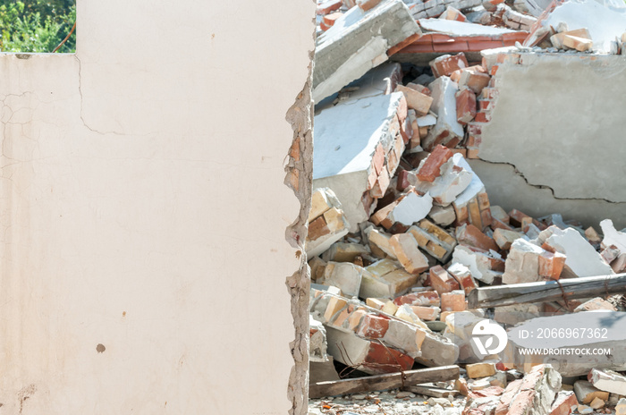 Aftermath remains of hurricane or earthquake disaster damage on ruined old house with collapsed roof and brick walls selective focus