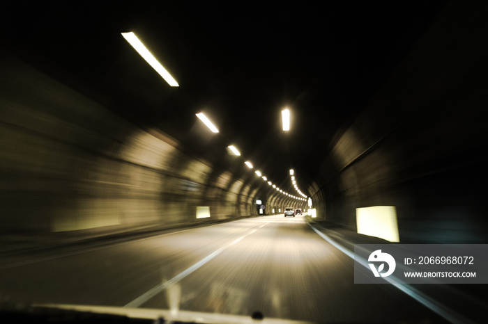 driving through an illuminated tunnel, point of view, motion blur