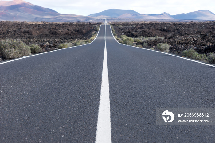 Endless highway through the volcanic landscape. Lanzarote. Canary islands. Spain