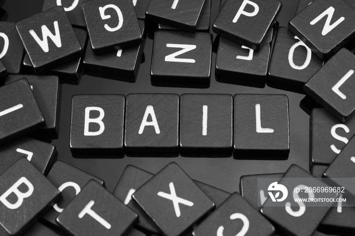 Black letter tiles spelling the word  bail  on a reflective background