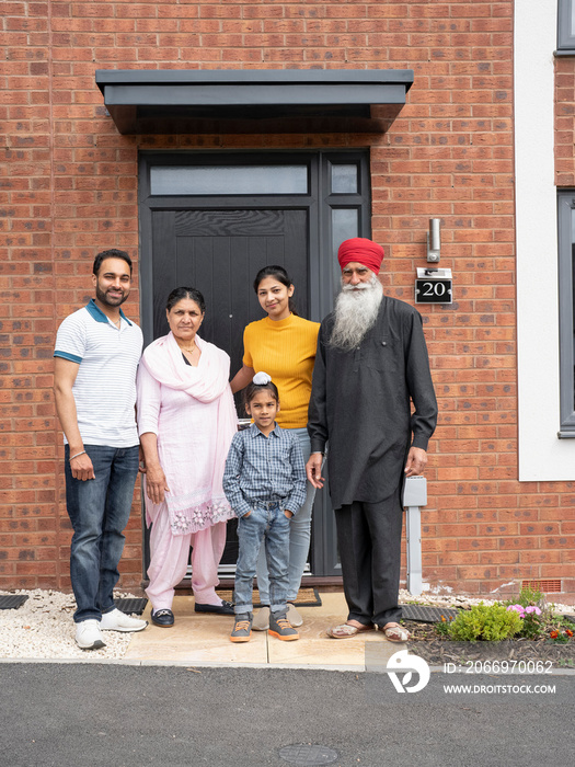 Portrait of multi-generation family (6-7) standing on front porch