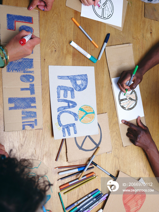 People making protest signs with symbols of peace