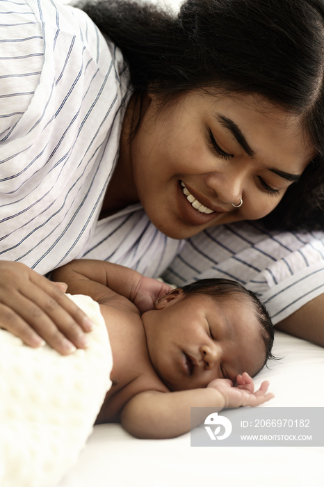 mixed race mother african american and asian watching newborn infant