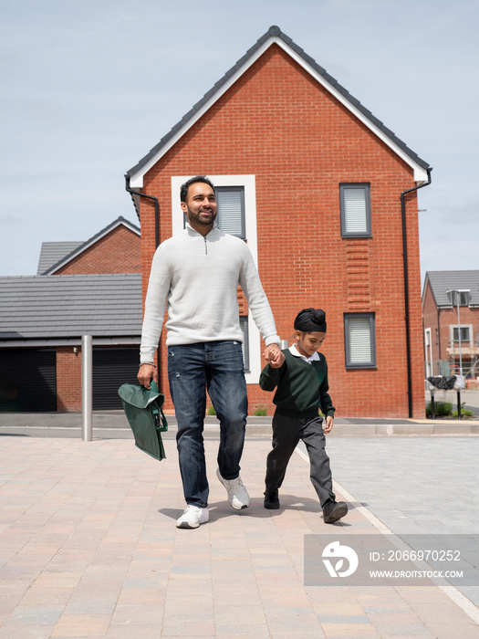 Father walking son (6-7) to school