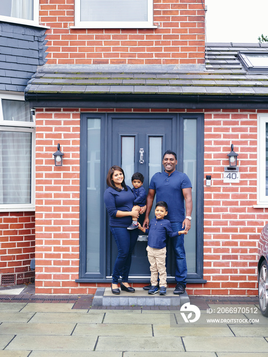 Portrait of family with sons standing on doorstep