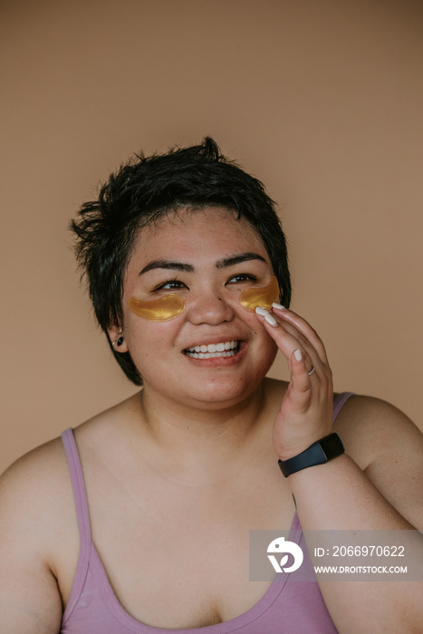 portrait of a plus size filipino woman practicing skincare