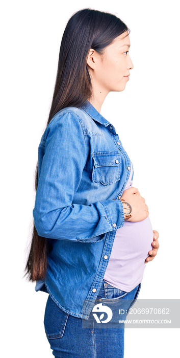 Young beautiful chinese woman pregnant expecting baby looking to side, relax profile pose with natural face and confident smile.