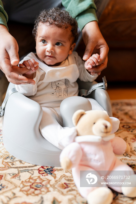 Father assisting baby daughter at home