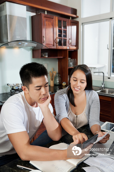 Wife showing her husband ammount of taxes they need to pay