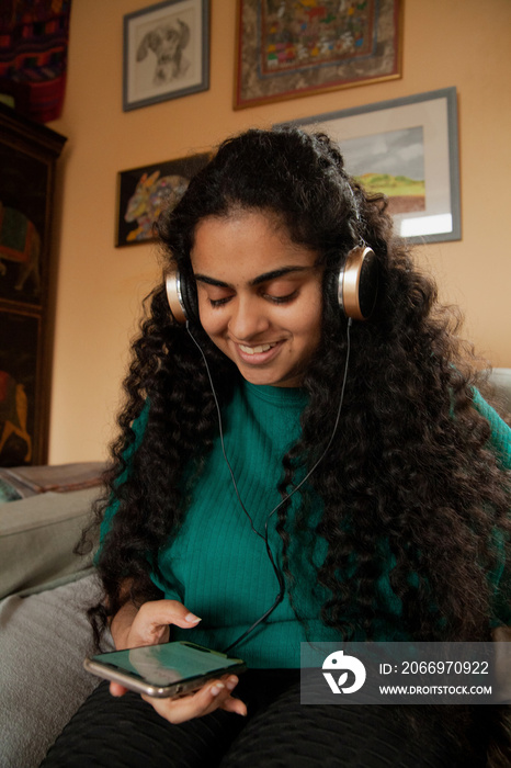 Curvy Indian girl with Cerebral Palsy wearing headphones in her living room