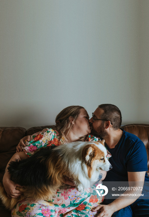 plus size couple kisses while bolding dog