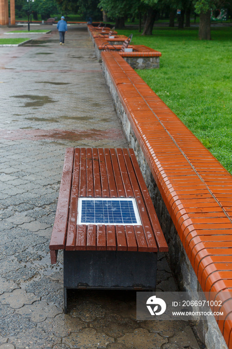 A bench with a built-in solar panel for charging phones.