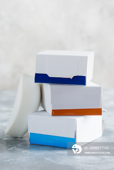 Set from three paper mock up boxes for packaging spa soap products on a marble grey background.