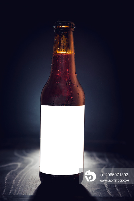 Blank label on the beer bottle on dark background