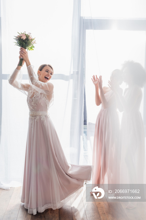 excited bride throwing wedding bouquet near bridesmaids.