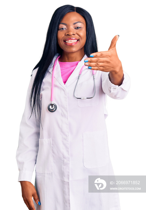 Young african american woman wearing doctor stethoscope smiling friendly offering handshake as greeting and welcoming. successful business.