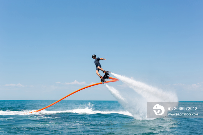 Water extreme sport. The guy is flying at the aquatic flyboard. A lot of water pressure