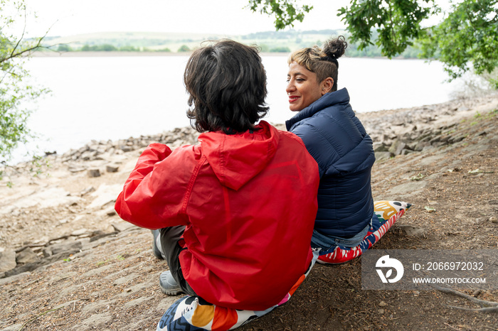 Mother and son relaxing by lake