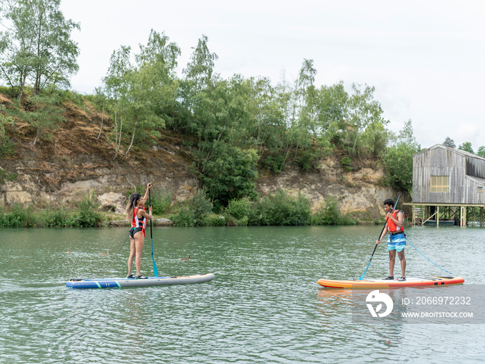 Friends paddleboarding on lake