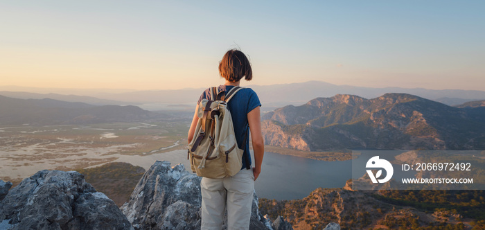 Travel to Turkey, viewpoint over Dalyan Iztuzu Beach. . Smiling woman taking break on hiking trip looking at view at sunset. Explore natural wonders of Turkey