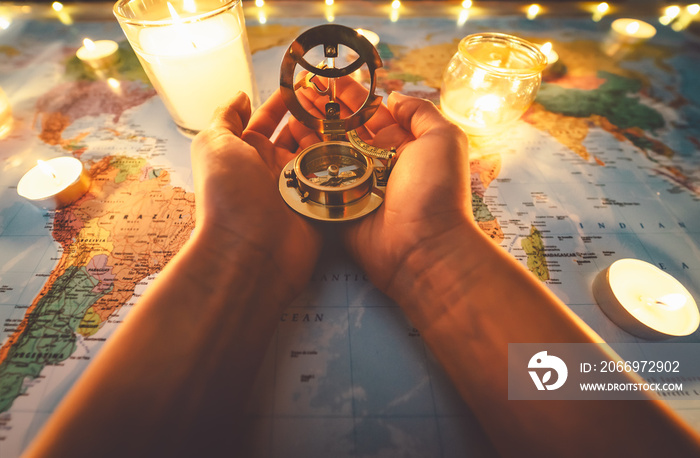 Top view female hands planning vacation equipped with world map and vintage nautical compass - Travel tour adventure lifestyle people and discovering destinations concept