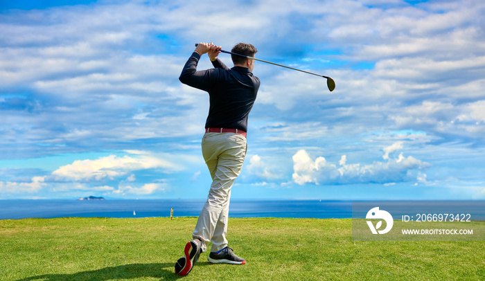 Golfer on the professional golf course. Golfer with golf club hitting the ball for the perfect shot.