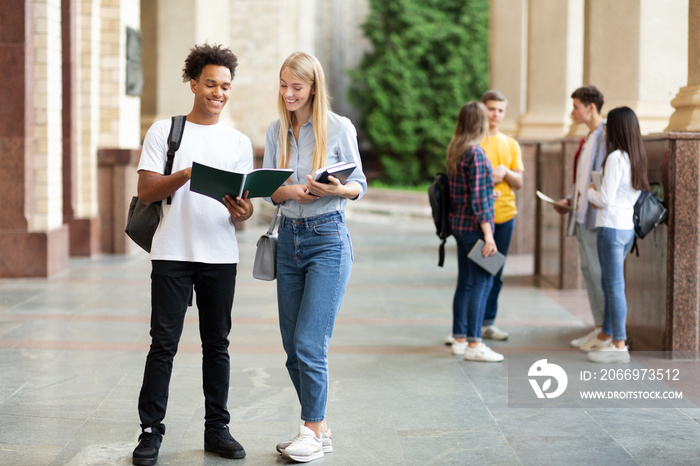 Teens preparing for classes with books in university campus