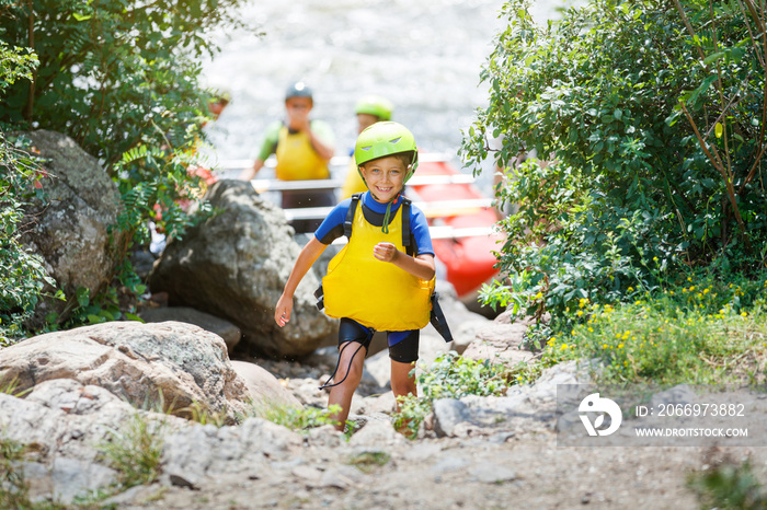 Cute boy in helmet and live vest ready for rafting on the catamaran