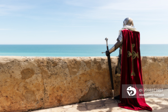 Medieval Templar soldier watches the coastline from the wall