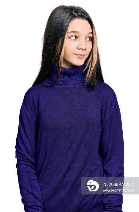 Young brunette girl with long hair wearing turtleneck sweater smiling looking to the side and staring away thinking.