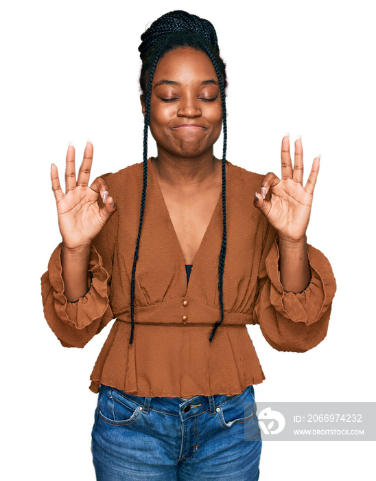 Young african american woman wearing casual clothes relax and smiling with eyes closed doing meditation gesture with fingers. yoga concept.