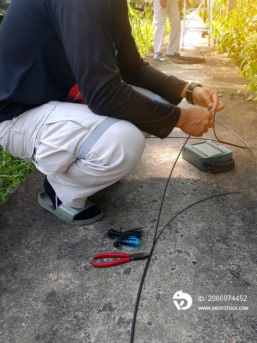 Technician repairing broken fiber optic cable outdoors on site
