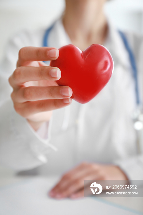 Cardiologist with red heart in clinic, closeup