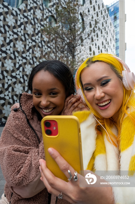 Smiling young friends listening to music