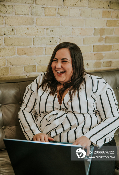 plus size Metis woman works on laptop laughing